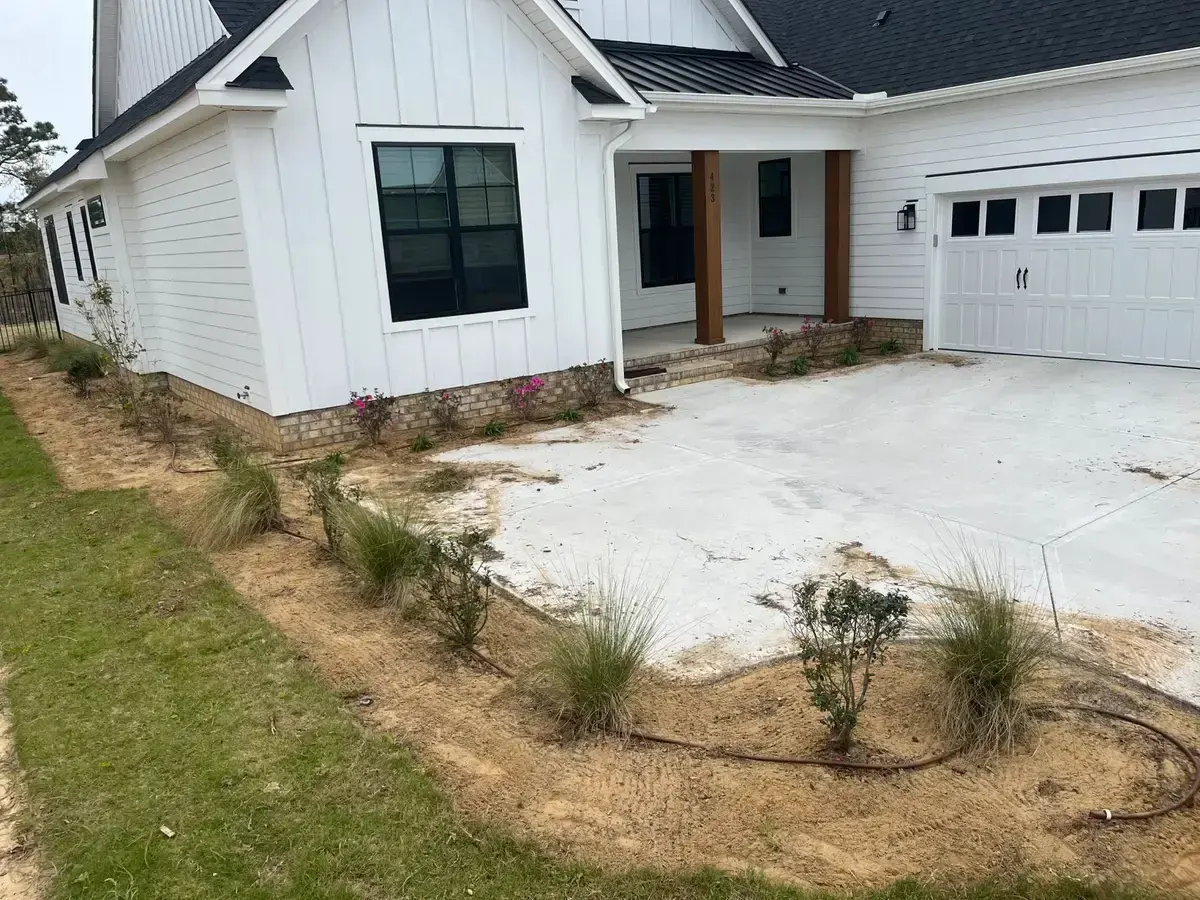 Bare sand beds and sparse plantings before the mulch install